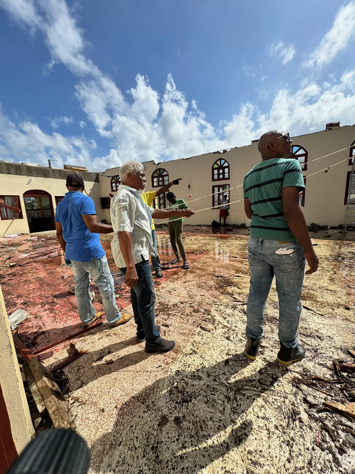Community leaders assessing a storm-damaged building in Jamaica